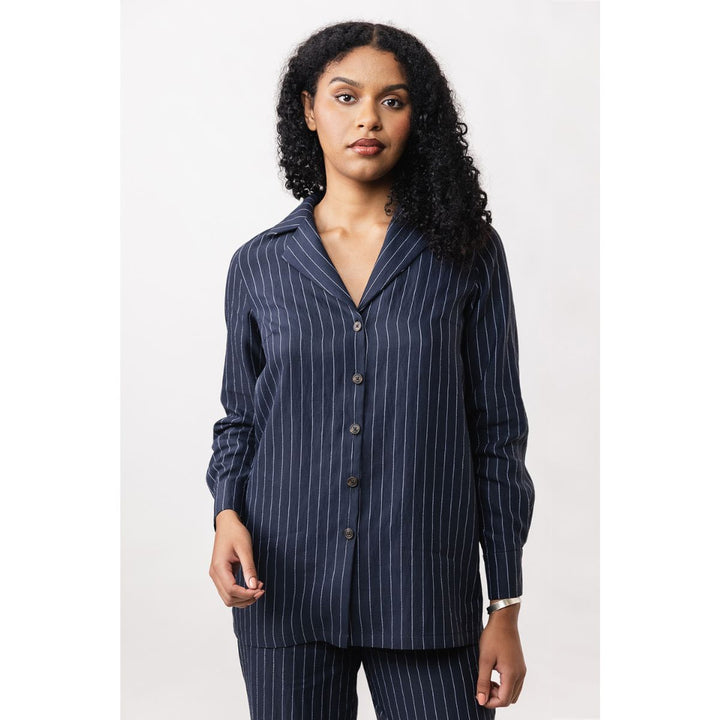 Woman wearing a navy pinstripe shirt with a white background