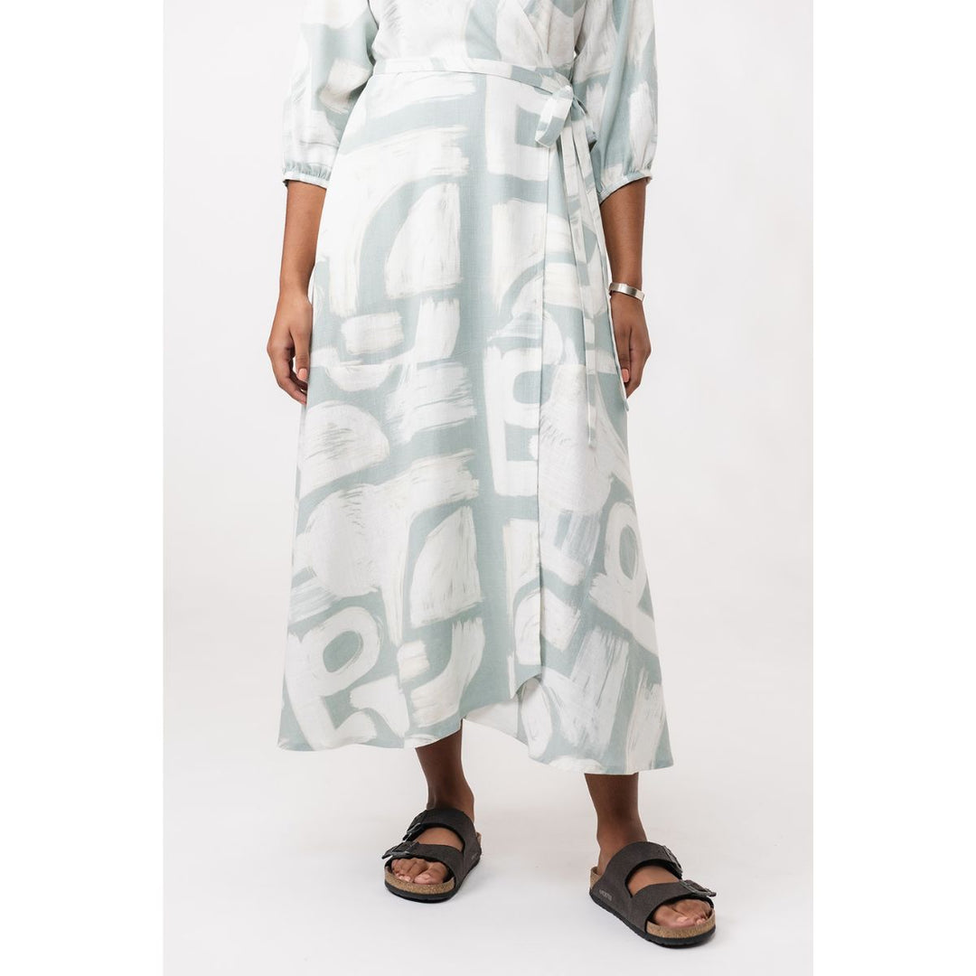 Person wearing a light blue and white patterned dress on a white background