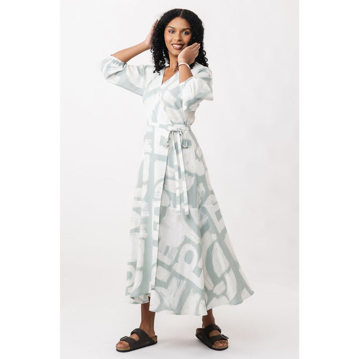 Woman wearing a long, light-colored dress with a pattern on a white background