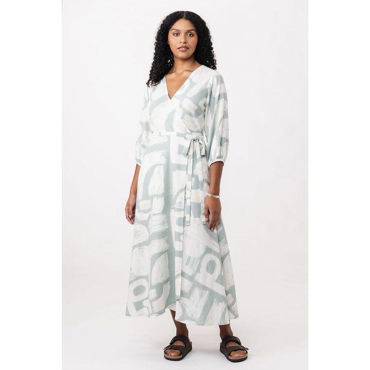 Woman wearing a long, light-colored dress with abstract patterns on a white background