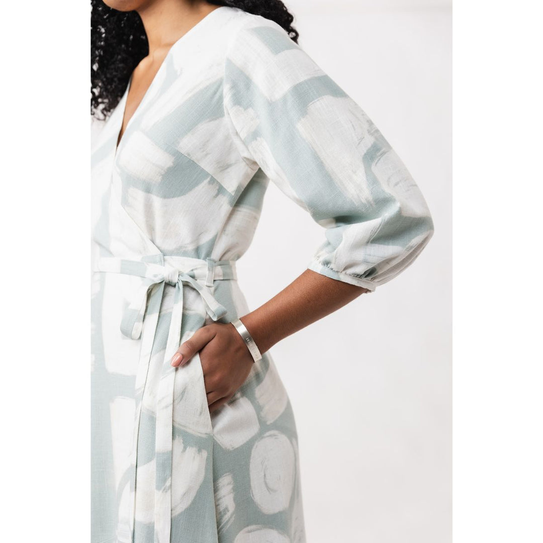 Woman wearing a light blue and white patterned robe against a white background