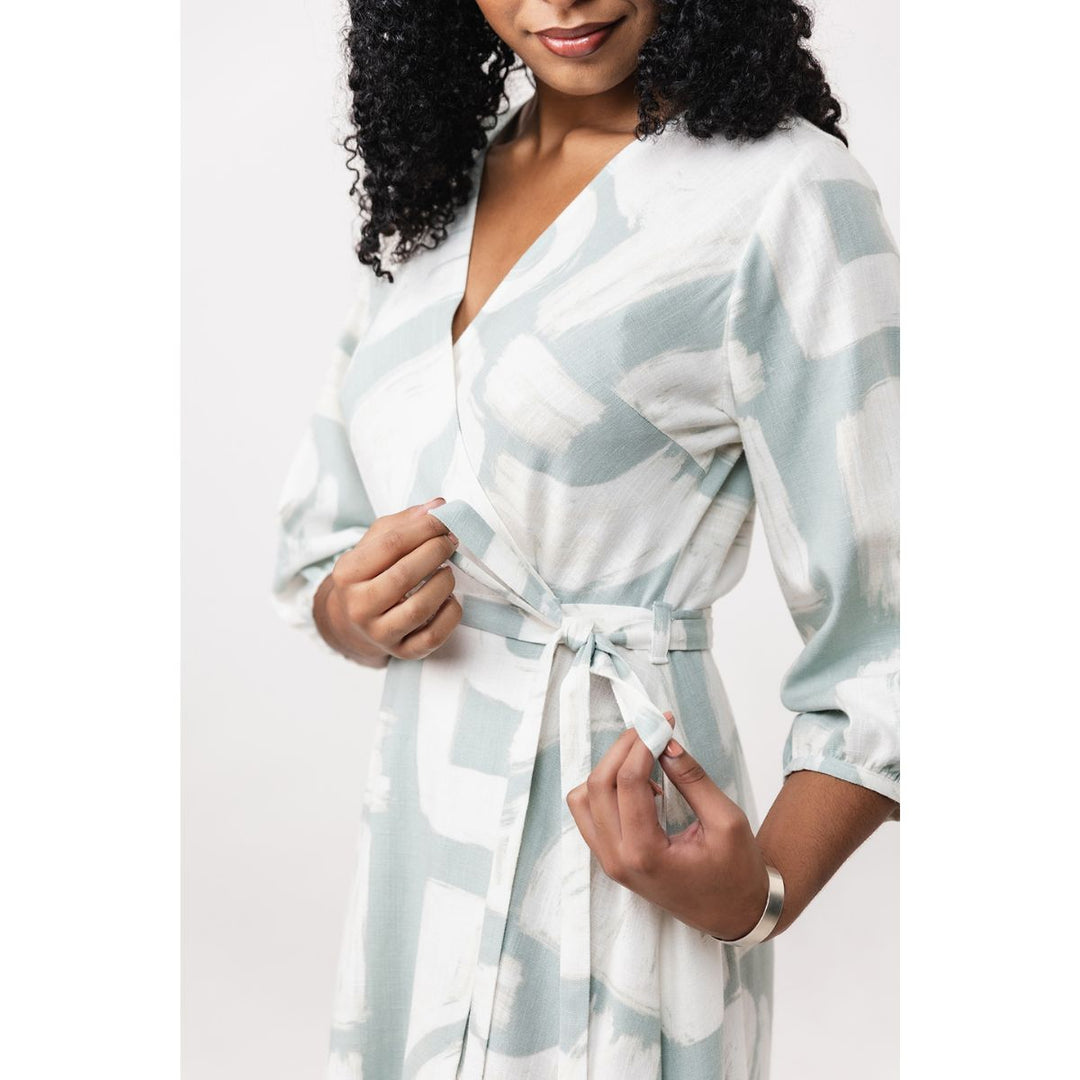 Woman wearing a light blue and white patterned robe on a plain background