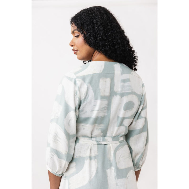 Woman wearing a light gray and white patterned robe against a white background