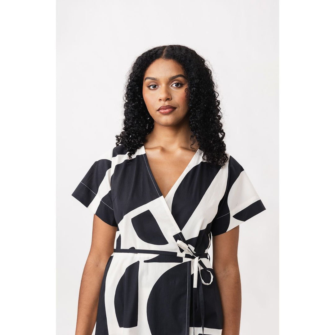 Woman wearing a black and white patterned dress on a white background