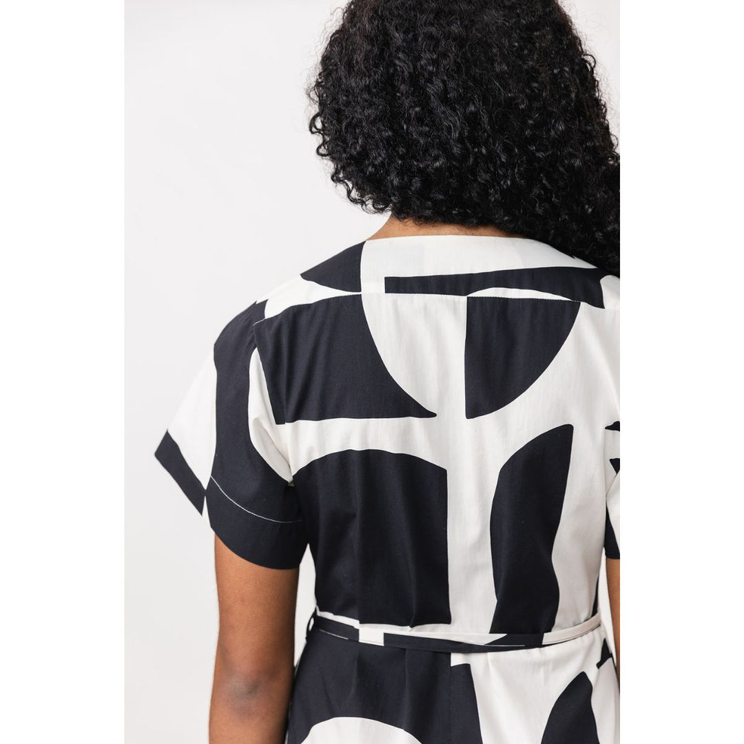 Person wearing a black and white abstract patterned outfit on a plain background