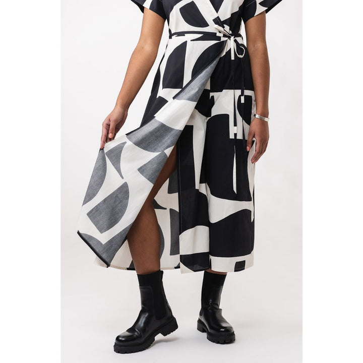 Person wearing a black and white patterned dress on a white background