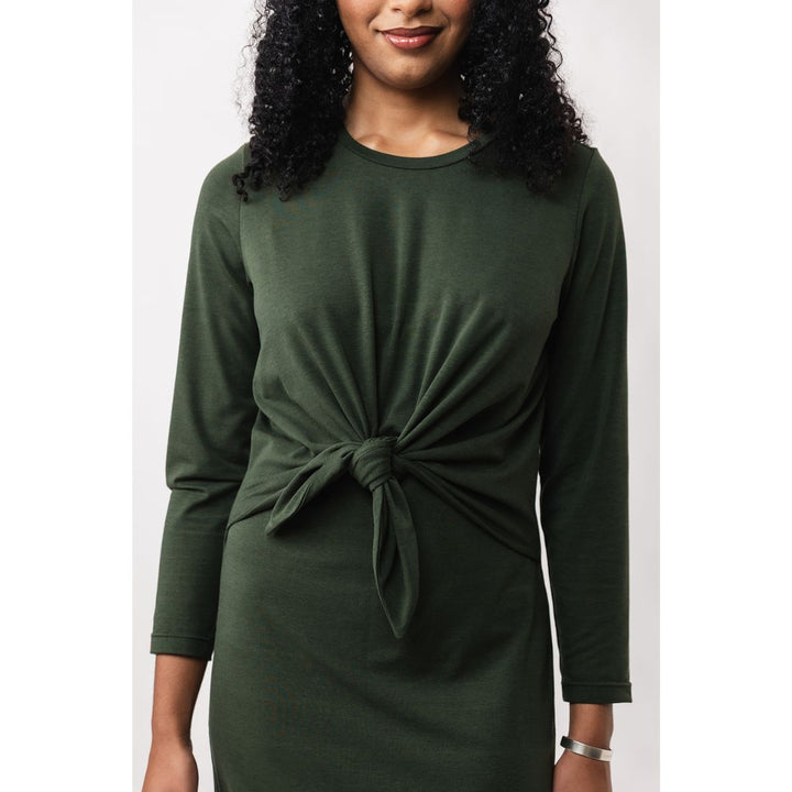Woman wearing a green dress with a knot detail on a white background