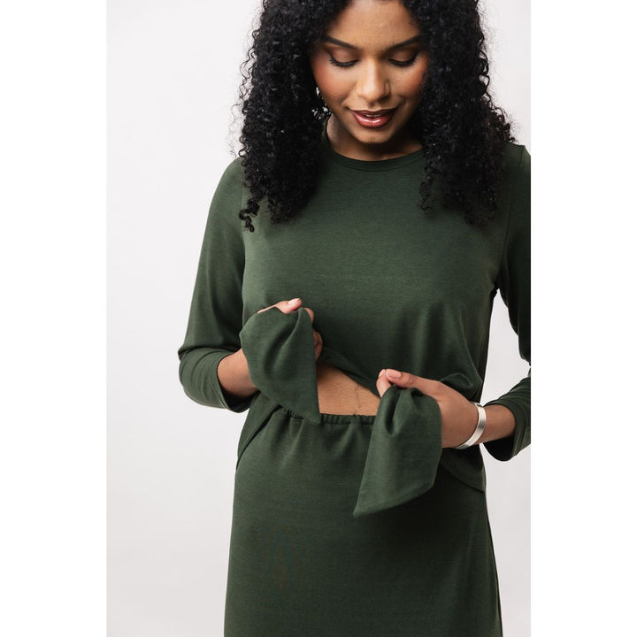 Woman wearing a green dress with cut-out design on a white background