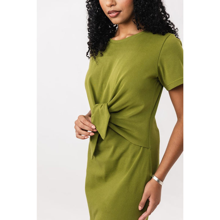 Woman wearing a green dress with a knot detail on a white background