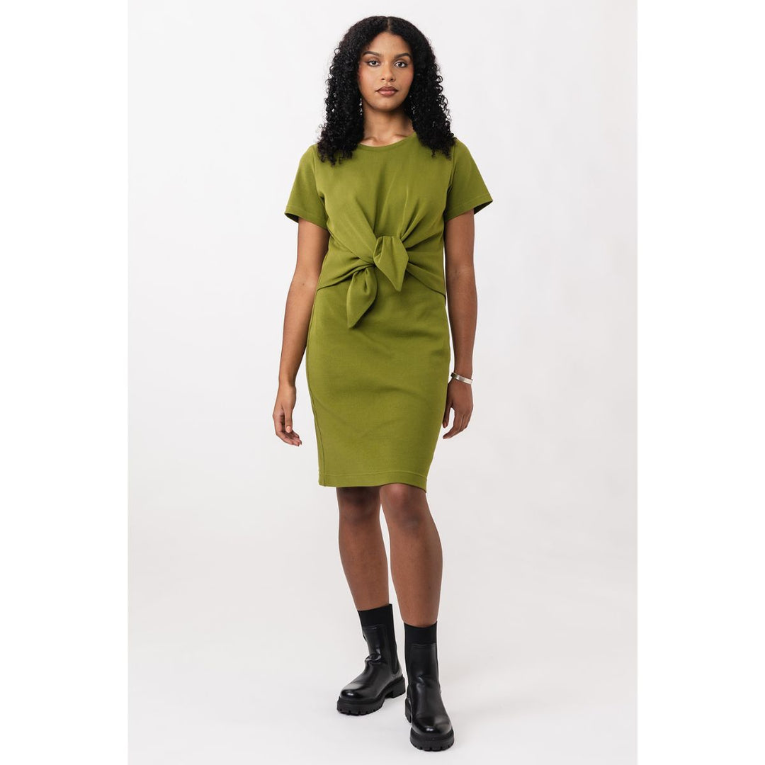 Woman wearing a green dress with a knot detail on a white background