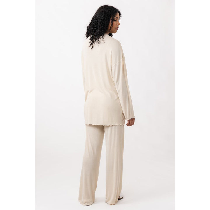 Woman wearing a cream-colored outfit on a white background