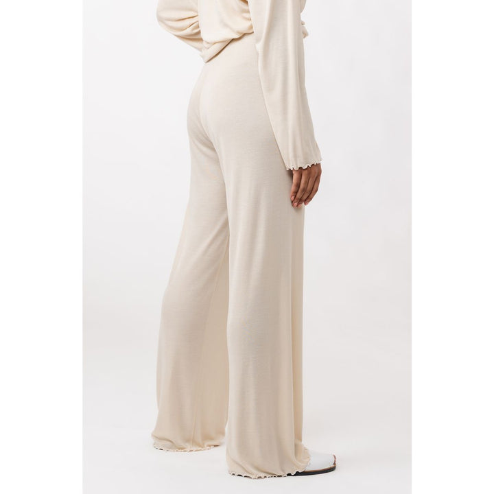 Beige outfit with a long-sleeve top and wide-leg pants on a white background