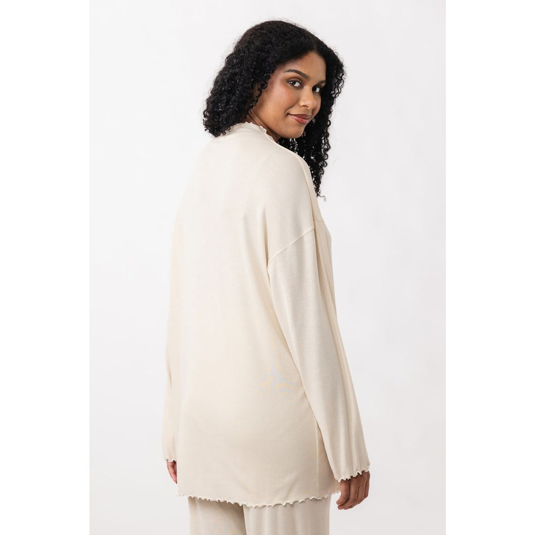 Woman wearing a cream-colored outfit on a white background