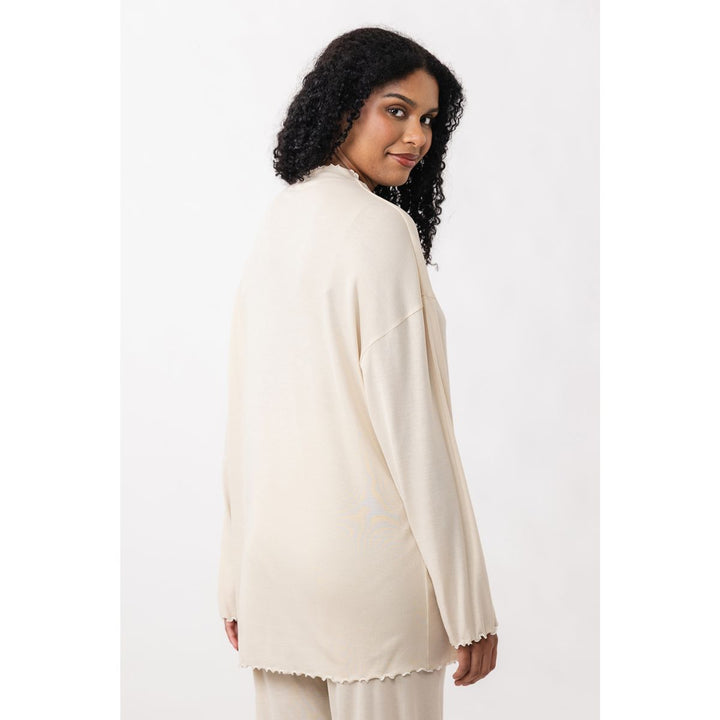 Woman wearing a cream-colored outfit on a white background