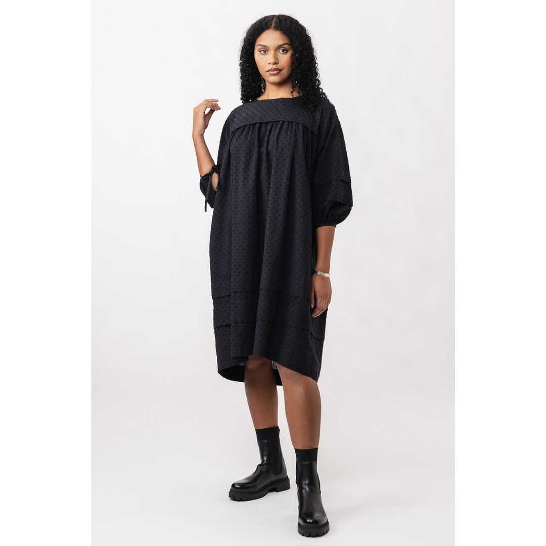 Woman wearing a black dress with a white background