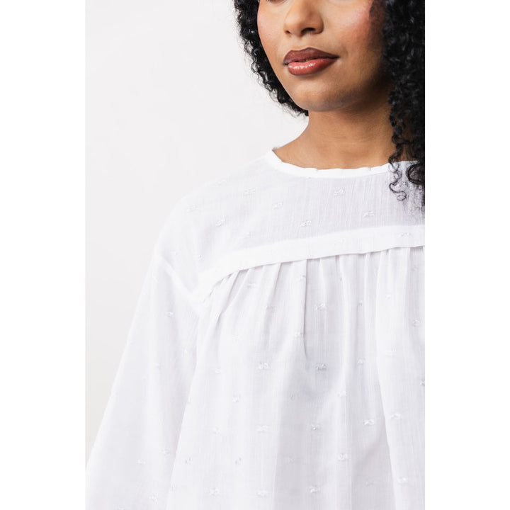 Woman wearing a white dress with a plain background