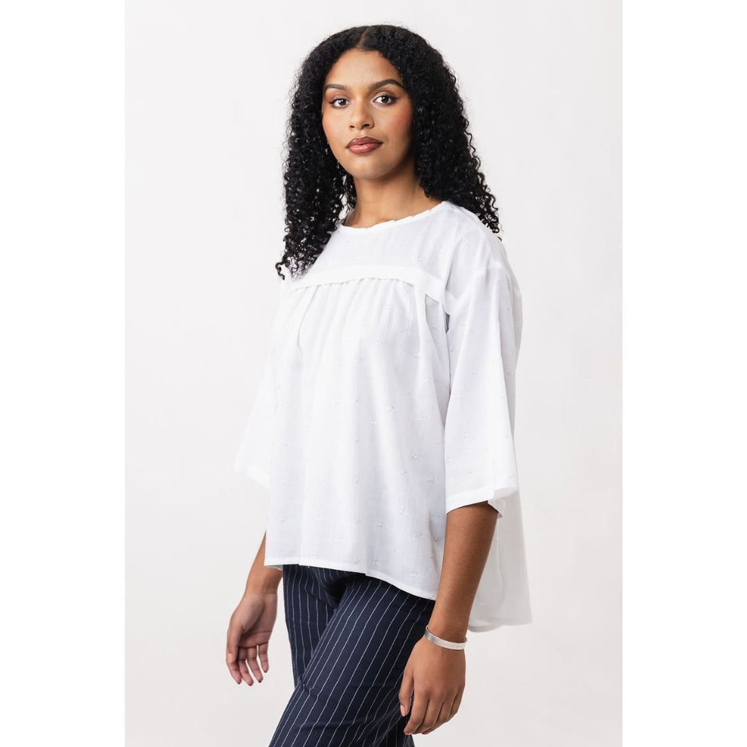 Woman wearing a white blouse with a plain background