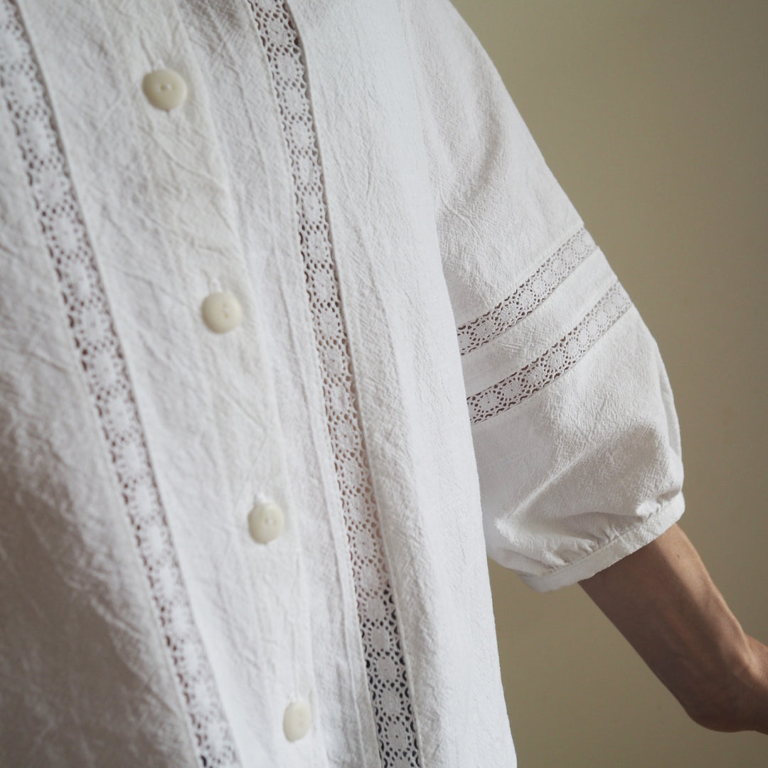 Close-up of lace detail on the front of the blouse, and sleeve on the Nepheline blouse