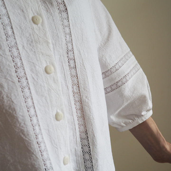 Close-up of lace detail on the front of the blouse, and sleeve on the Nepheline blouse