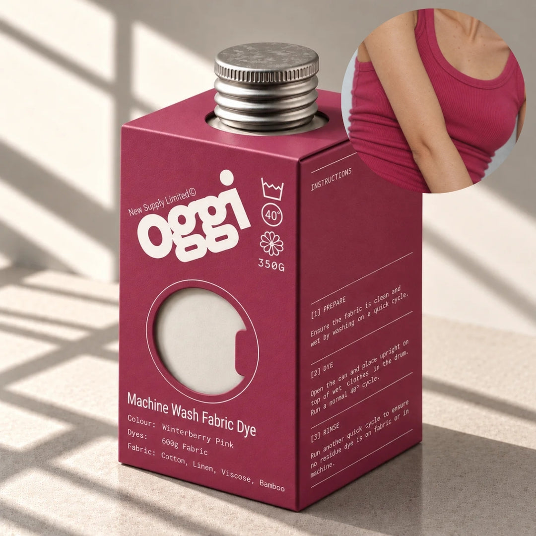 A box of Oggi Machine Wash Fabric Dye in Watermelon Pink, shown on a tabletop with a circular inset showing a person's torso wearing the dyed fabric on a tank top.