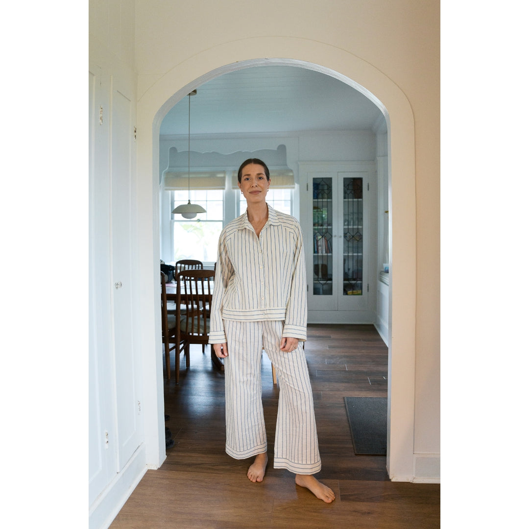 Person wearing striped pajamas standing in a home interior.