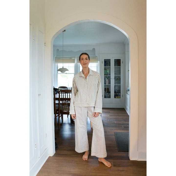 Person wearing striped pajamas standing in a home interior.