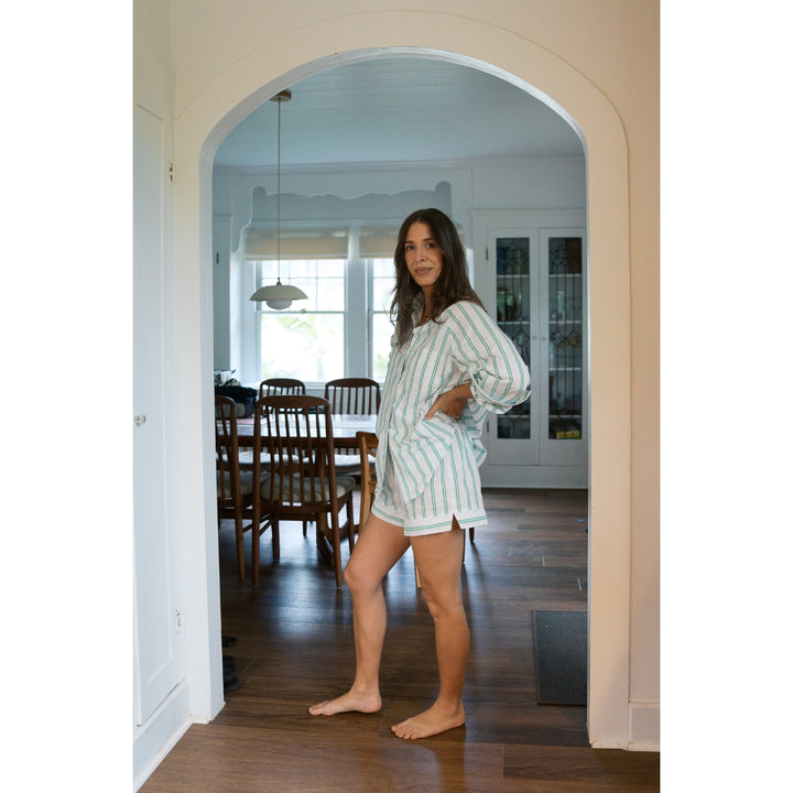 Woman standing in a home interior wearing a striped outfit.