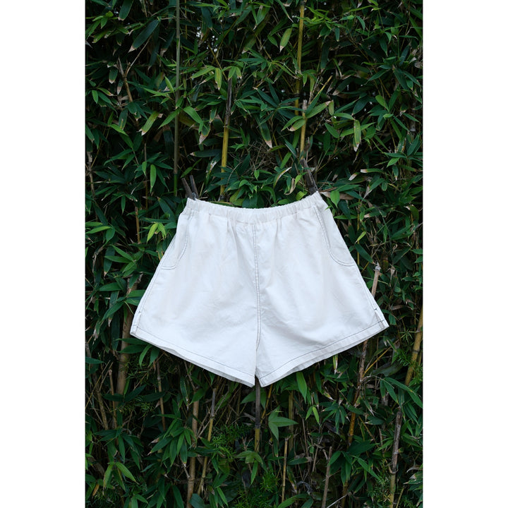 White shorts hanging on a bamboo plant