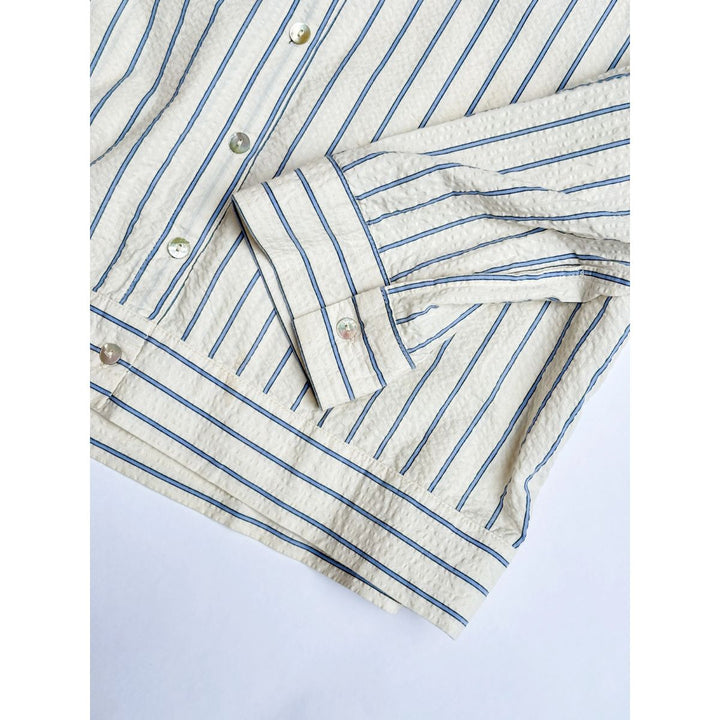 Close-up of a striped shirt with blue and white lines on a light gray background