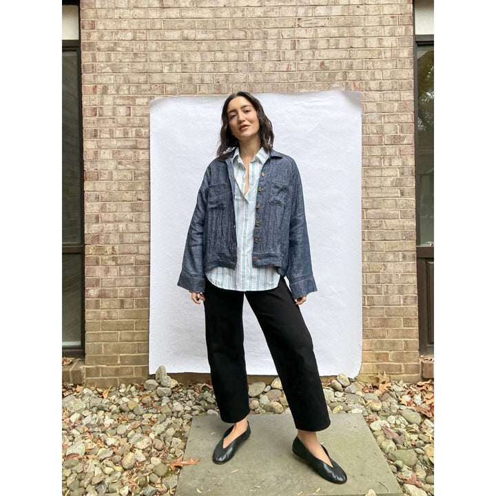 Woman standing in front of a white backdrop with a brick wall background