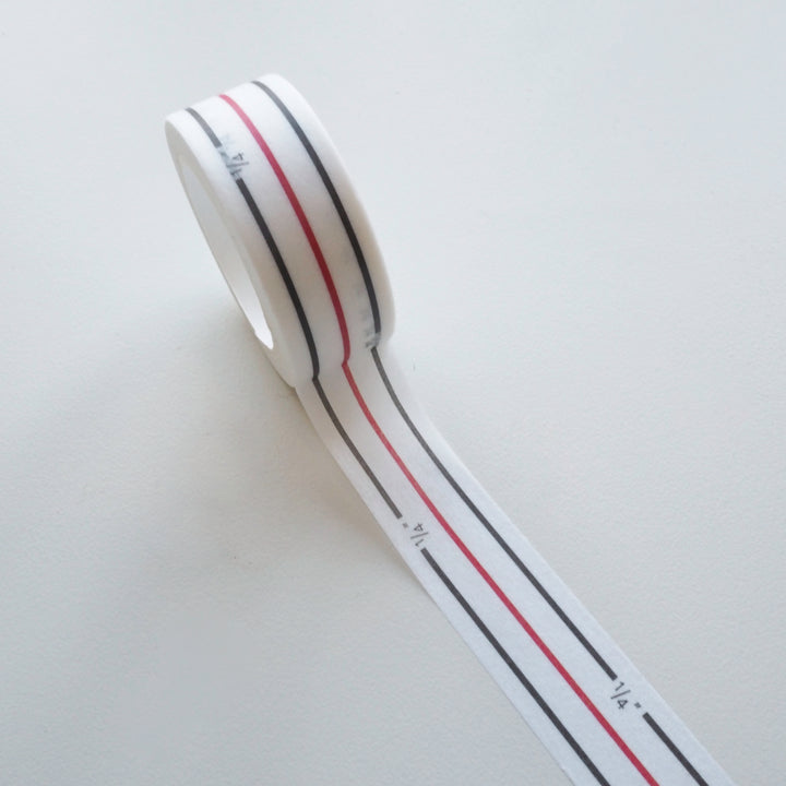 Roll of white tape with red and black stripes on a light gray background