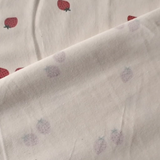 Ecru stretch cotton jersey dressmaking fabric with strawberry motifs