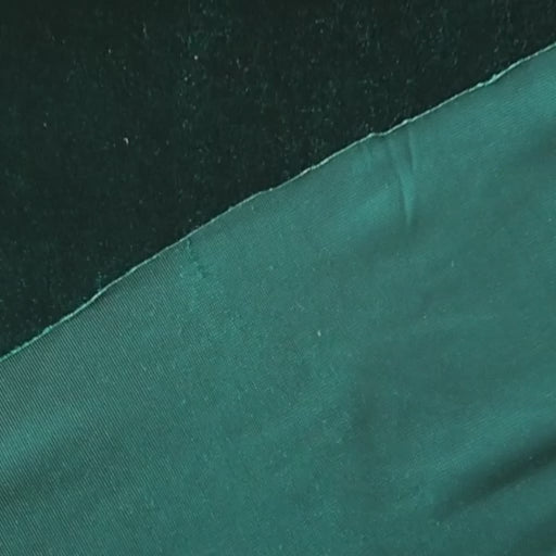 Emerald green stretch velour fabric with soft sheen for dressmaking.