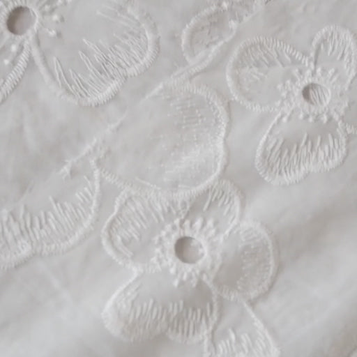 White embroidered cotton dressmaking fabric with floral pattern