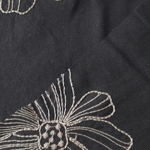 Black viscose linen dressmaking fabric with white floral embroidery pattern