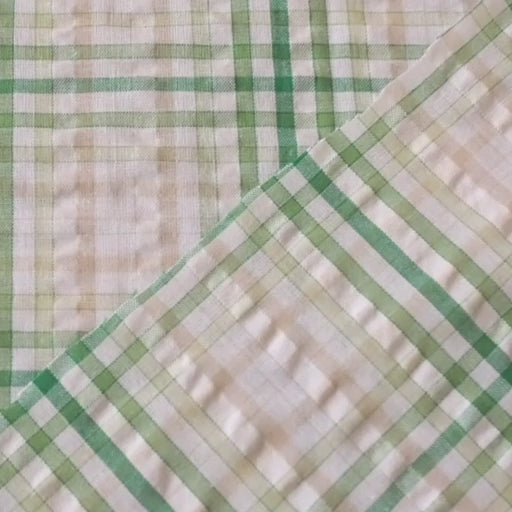 Cotton dressmaking fabric with green check on a white background