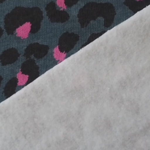 Leopard print fleeceback sweatshirt fabric with black and pink spots on an indigo blue background
