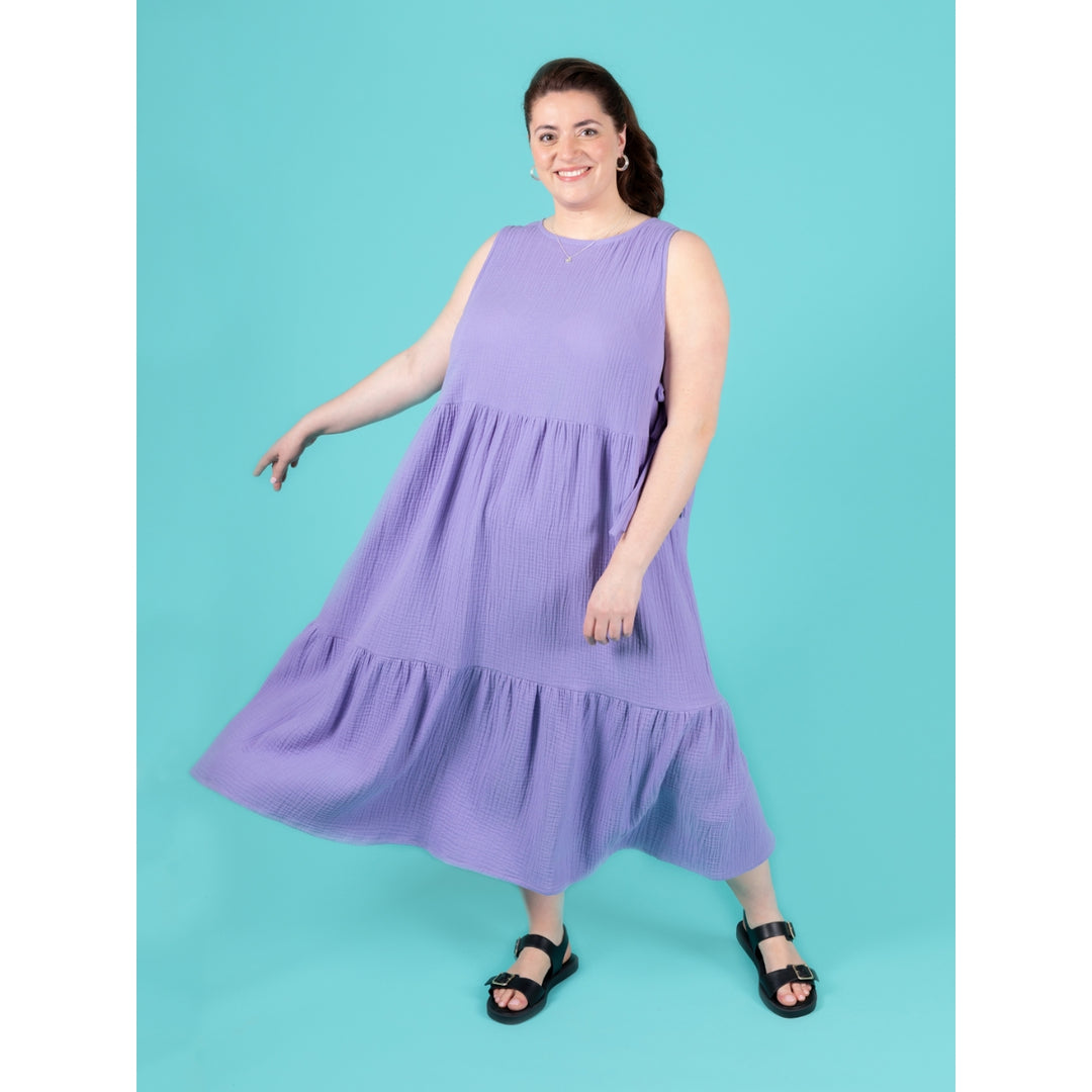 Woman wearing a purple dress against a teal background