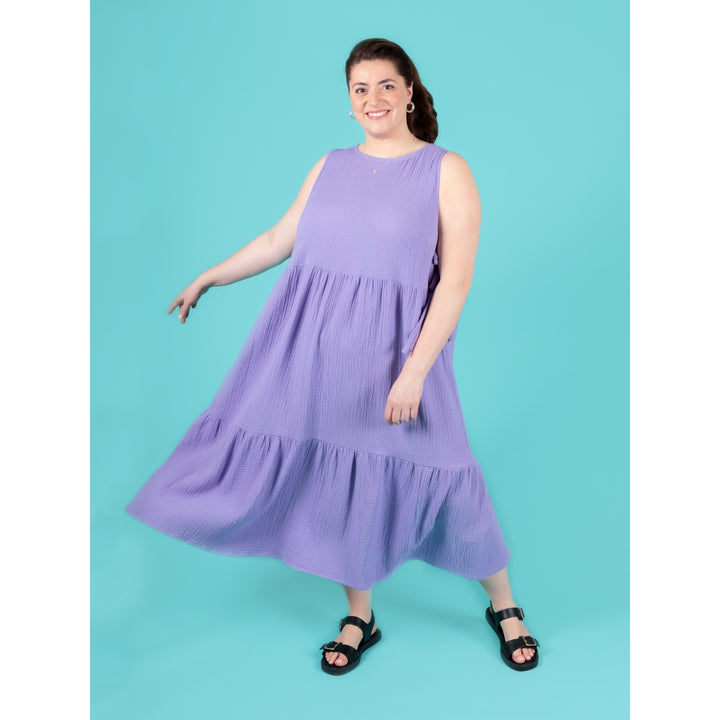 Woman wearing a purple dress against a teal background