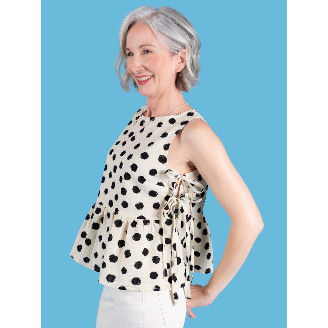 Woman wearing a polka dot top against a blue background