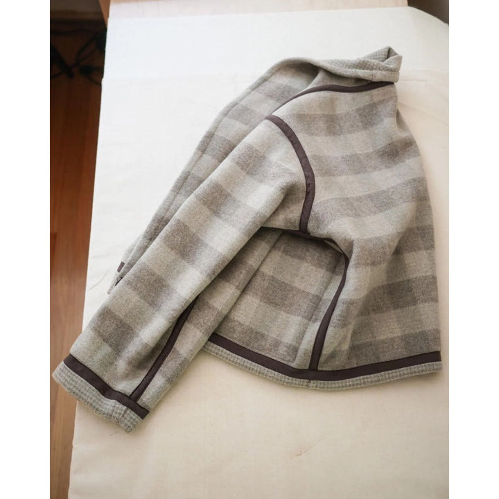 Folded checkered jacket on a white surface